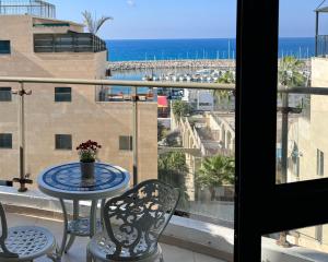 a balcony with a table and chairs and a view of the ocean at Marina View in Ashkelon