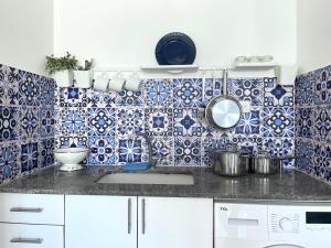 a kitchen with blue and white tiles on the wall at Marina View in Ashkelon