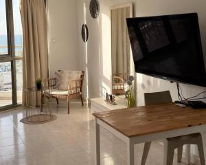 a living room with a large flat screen tv on a wall at Marina View in Ashkelon