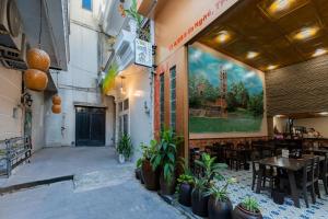 a restaurant with tables and potted plants on the side of a building at Chic Studio Homestay in Hue