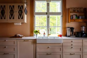 a kitchen with a sink and a window at Stay North - Mustio in Inkoo +34 photos