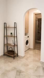 a laundry room with a washer and a washing machine at Azalea Guesthouse in Andros