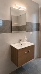 a bathroom with a sink and a mirror at Azalea Guesthouse in Andros