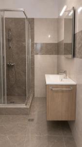 a bathroom with a sink and a shower at Azalea Guesthouse in Andros