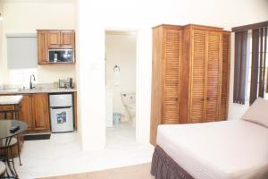 a bedroom with a bed and a kitchen with a sink at The Vista Inn Studio #4 in Falmouth