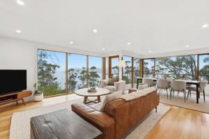 a living room with a couch and a dining room at Bush Escape with Water Views in Tinderbox