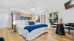 a bedroom with a bed and a table and chairs at Absolute Beachfront Studio with Pool and Ocean Views in Palm Cove