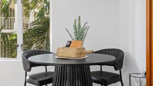 a black table with chairs and a book on it at Absolute Beachfront Studio with Pool and Ocean Views in Palm Cove