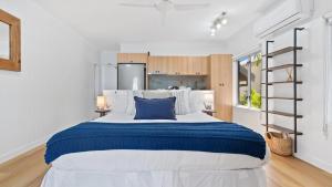 a bedroom with a large bed with blue and white sheets at Absolute Beachfront Studio with Pool and Ocean Views in Palm Cove +22 photos