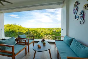 a living room with a couch and a large window at Luxury Oceanview Condo Rooftop Infinity Pool in Las Terrenas