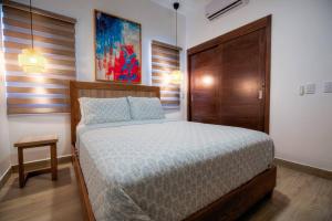 a bedroom with a bed with a wooden headboard at Luxury Oceanview Condo Rooftop Infinity Pool in Las Terrenas