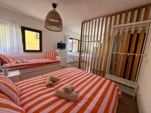 a bedroom with two beds and towels on a bed at Peniche Surf & Sunset House in Peniche
