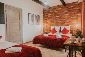 a bedroom with two beds and a brick wall at Cztery Kąty Zator Energylandia Przeciszów in Przeciszów