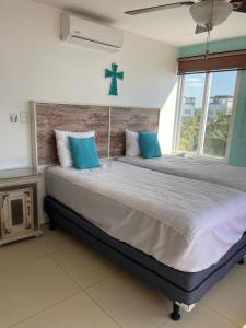 a large bed with blue pillows in a bedroom at Casa Aqua in Monterrico +12 photos