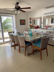 a dining room with a glass table and chairs at Casa Aqua in Monterrico