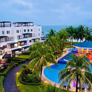 an aerial view of a resort with a pool and palm trees at Casa Aqua in Monterrico