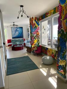 a living room with colorful walls and a large window at Casa Aqua in Monterrico