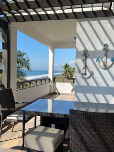 a patio with a table and a view of the ocean at Casa Aqua in Monterrico