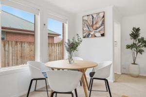 a dining room with a table and white chairs at Stylish West Hobart Villa in West Hobart +26 photos