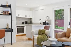 a kitchen and living room with a couch and a table at Stylish West Hobart Villa in West Hobart