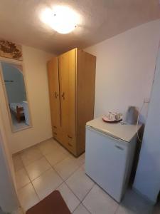 a small kitchen with a refrigerator and a cabinet at Iliada Skiathos rooms in Skiathos