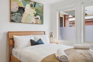 a white bedroom with a bed and a window at Stylish West Hobart Villa in West Hobart