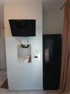 a flat screen tv on a white wall in a room at Iliada Skiathos rooms in Skiathos