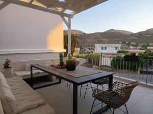a patio with a table and chairs on a balcony at Anoi Kalymnos in Khoríon