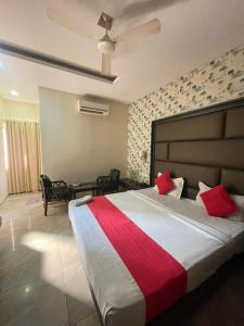 a bedroom with a large bed with red pillows at Hotel Surya Palace - Durg Railway Station in Durg