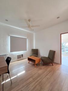 a living room with two chairs and a flat screen tv at Hotel Milton in La Paz