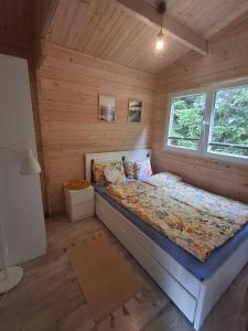 a bedroom with a bed in a wooden cabin at Urlopownia-Domki z Indywidulanym Ogrodzeniem-Dogfriendly-Duży,Zielony Teren in Gąski +84 photos