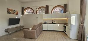 a kitchen with a couch and a sink and a refrigerator at Blue Living -Archi di Mare in Marciana Marina