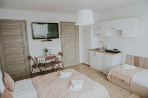 a bedroom with a bed and a kitchen with a table at Cztery Kąty Zator Energylandia Przeciszów in Przeciszów