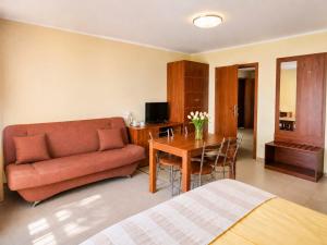 a living room with a couch and a table at Pensjonat Marynarski - Apartamenty in Darlowko