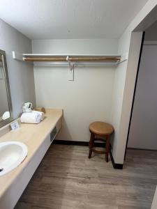 a bathroom with a sink and a wooden stool at Extend-a-Suites Phoenix in Phoenix +5 photos