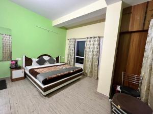a bedroom with a bed with green walls and a window at Wonder View in Shimla