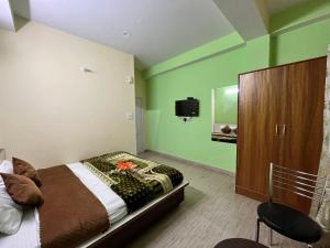 a bedroom with a bed and a tv on the wall at Wonder View in Shimla