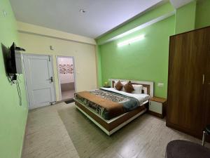 a bedroom with a bed with green walls and a television at Wonder View in Shimla