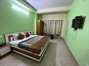 a bedroom with a bed and a flat screen tv at Wonder View in Shimla