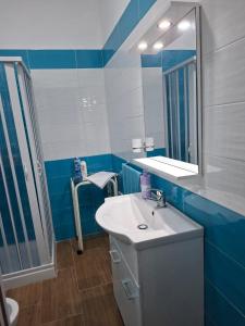 a blue and white bathroom with a sink and a mirror at Don Pedro Home in Naples +12 photos