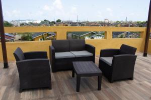 a patio with two chairs and a table and a balcony at The Vista Inn Studio #1 in Falmouth