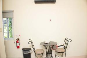 a table and chairs in a room with a fire extinguisher at The Vista Inn Studio #1 in Falmouth