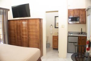 a bedroom with a bed and a kitchen with a sink at The Vista Inn Studio #1 in Falmouth
