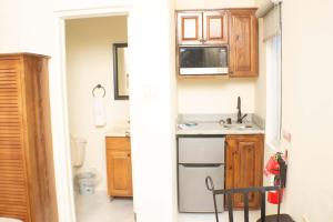 a kitchen with wooden cabinets and a sink at The Vista Inn Studio #1 in Falmouth