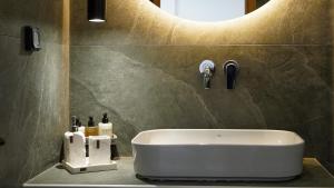 a bathroom with a white sink and a mirror at One Lemnos luxury Apartments in Lemnos +64 photos