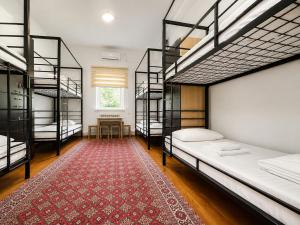 a room with four bunk beds and a red rug at Station Hostel in Atyrau