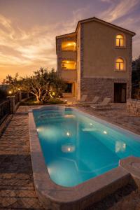a swimming pool in front of a house at Villas Verde Dalmatia in Jesenice