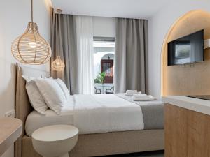a bedroom with a white bed and a tv at Pomelo Parga Cozy Studios in Parga