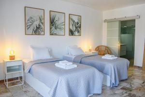 a bedroom with two beds with blue and white sheets at Casa Dos Amigos in Budens +22 photos