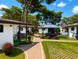 a garden with a picnic table and a gazebo at Domki Promyk in Mrzeżyno
